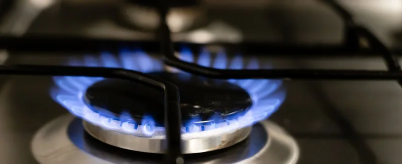 A blue gas flame on a hob burner, checked as part of a landlord gas safety inspection.